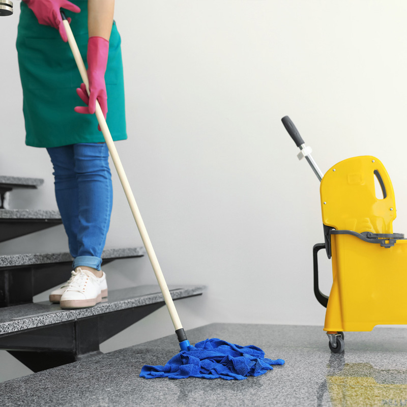 Une travailleuse de Thy Net Services effectue un nettoyage minutieux des escaliers des communs d'un immeuble